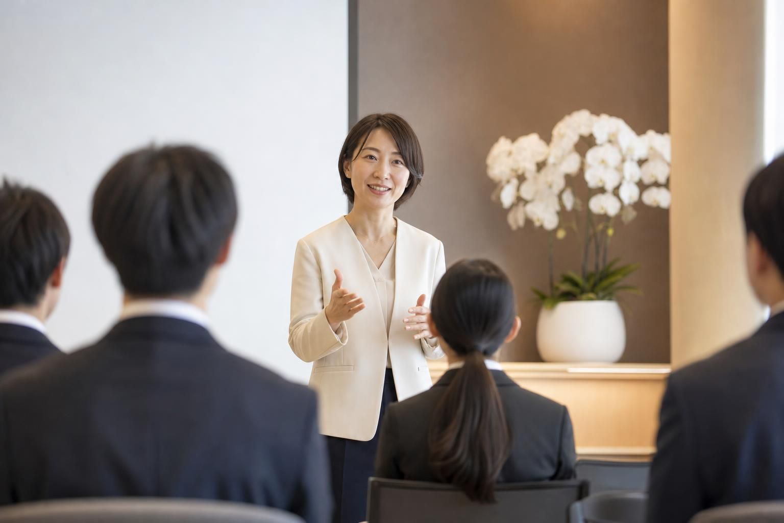会社説明会で女性社員が少人数の若い参加者に話している様子